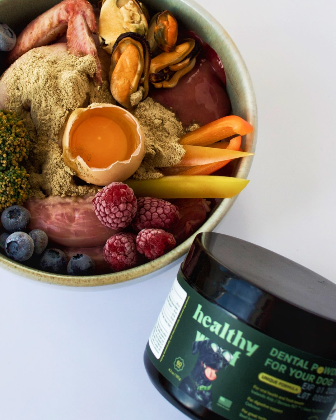 Healthy Woof dental powder beside a prepared dog meal, from the brand’s Instagram